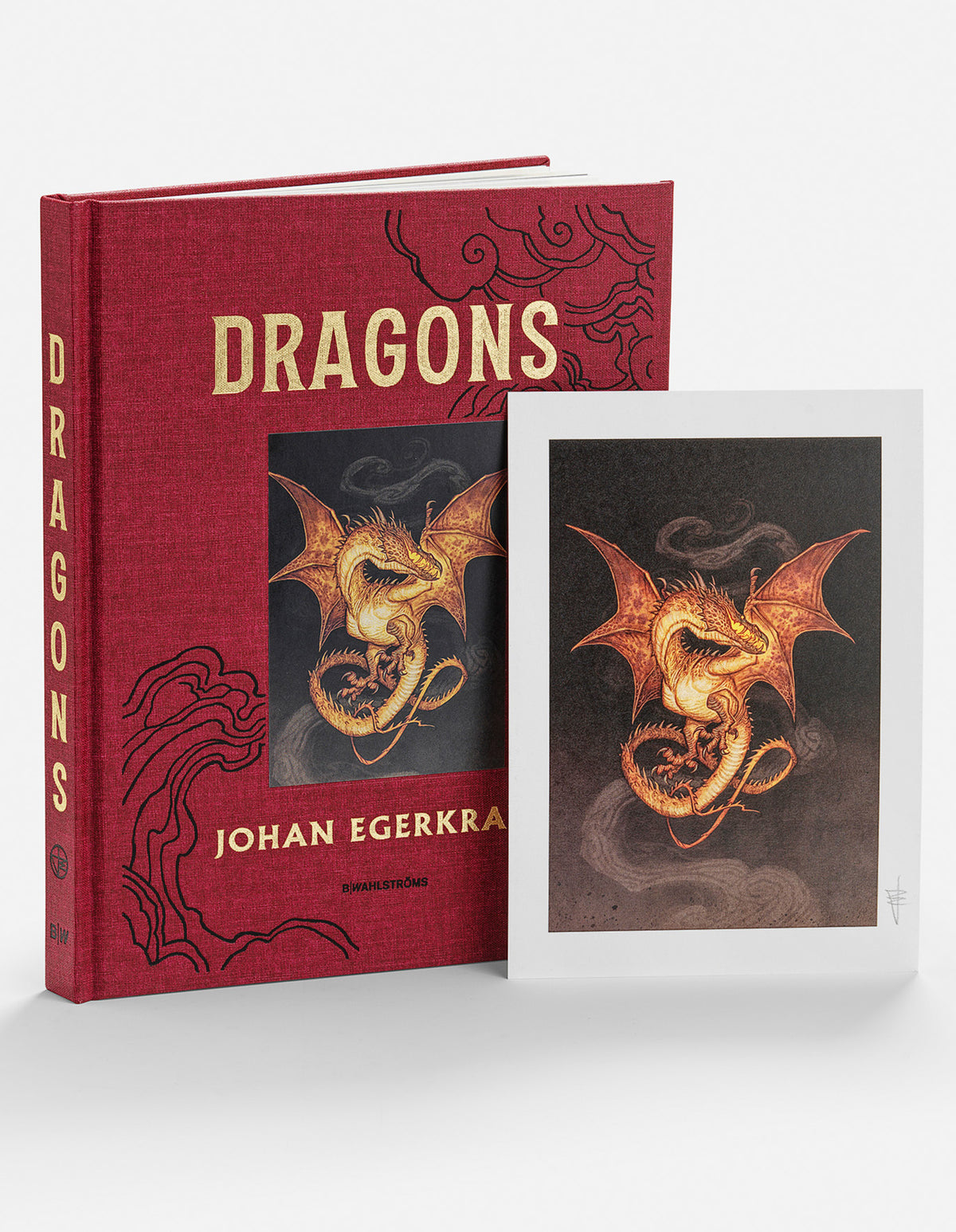 Dragons hardcover beside a signed art print of a coiled golden dragon with spread wings against dark smoke.