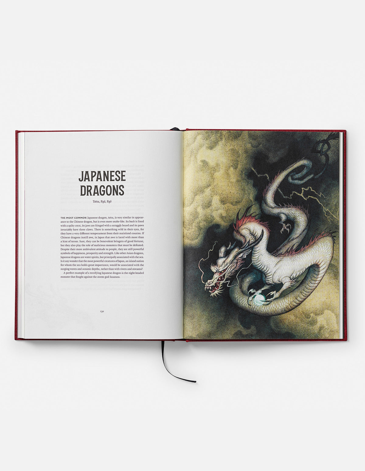 Open Dragons book at the Japanese Dragons chapter, showing a pale serpentine dragon coiling through dark clouds.