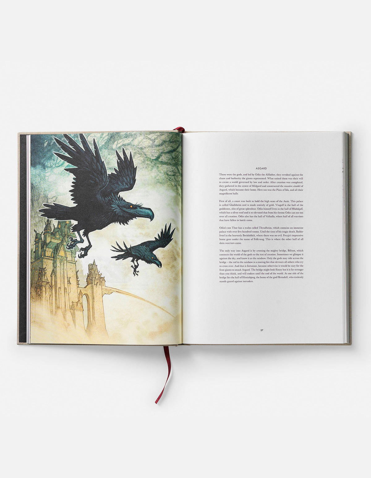 Open Norse Gods book at the Asgard section, showing two ravens flying above pale citadel towers.